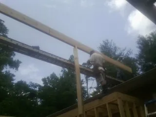 Carpenter setting a ridge beam over a new addition frame — Ice Dam Removal by Roofing Brothers in Salem