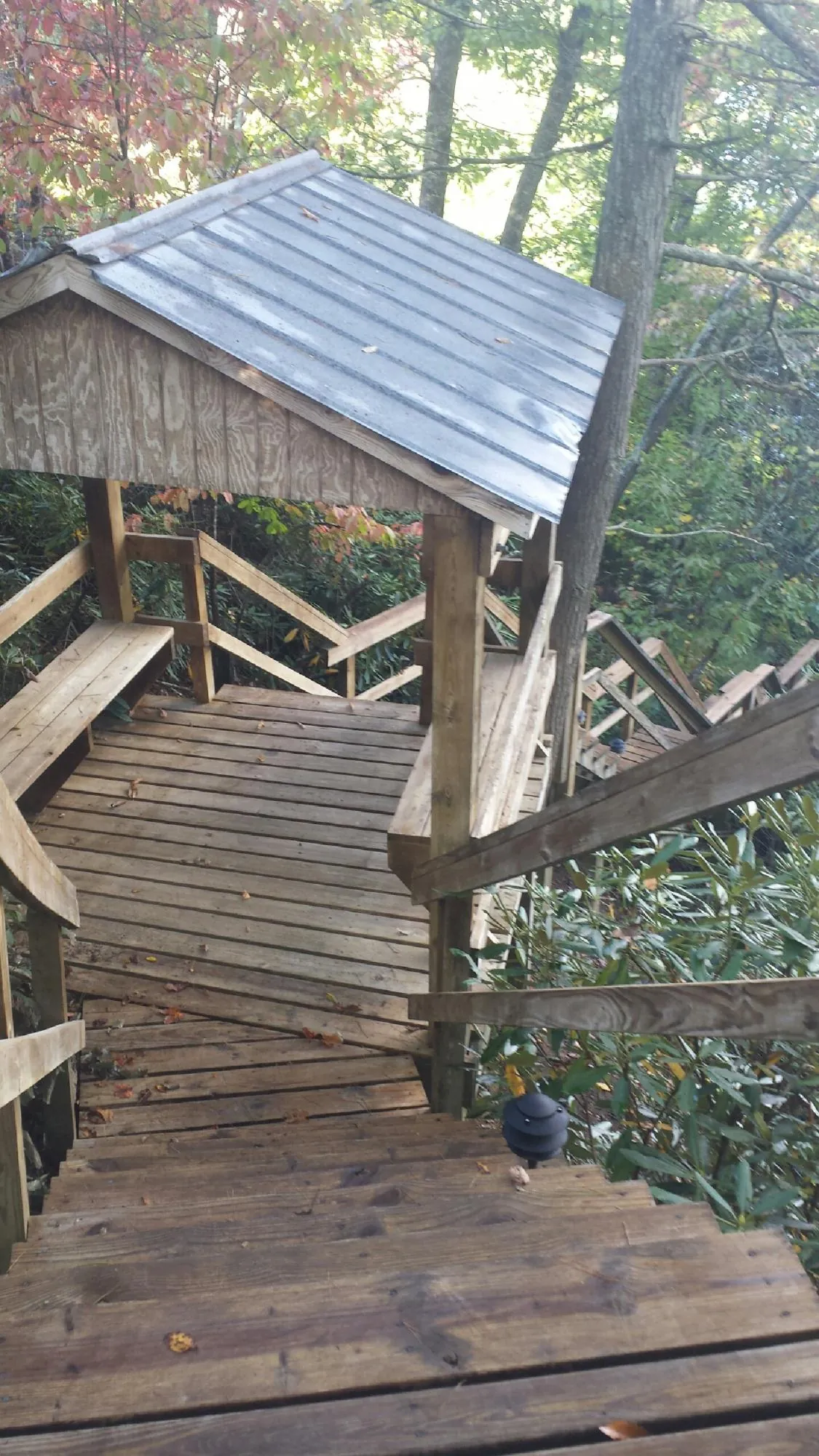Metal roofed shelter over wooden steps on a wooded walkway — Skylight Repair & Installation work by our crew in Salem